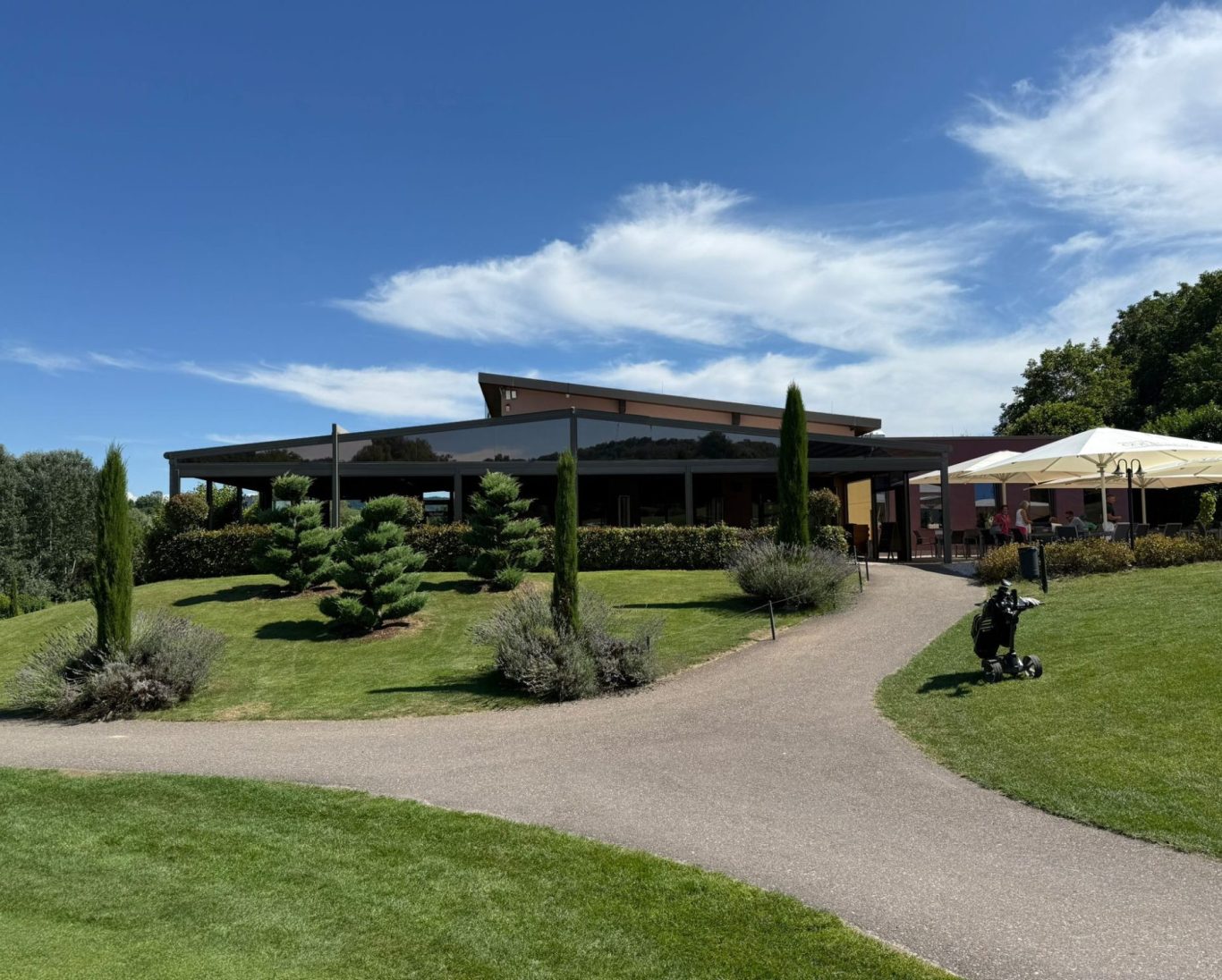 Rebland Restaurante Tutschfelden Restaurantgebäude mit Garten, Sonnenschirmen und gepflegter Landschaft.